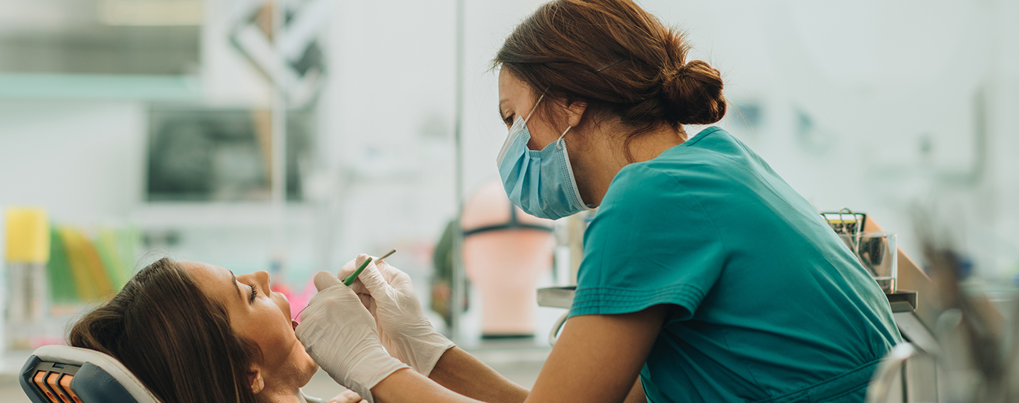 Dental hygienist cleaning a patient's teeth.